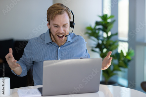 Caucasian man at home remote working on laptop computer talking with his colleague