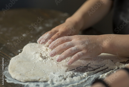 children's hands make dough on the table close-up.