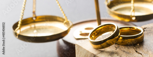 Divorce and separation concept. Two golden wedding rings, judge gavel.