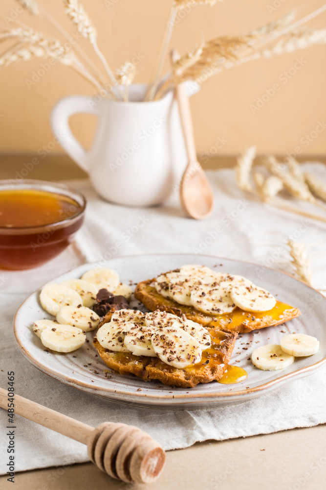 Ready to eat sandwiches with honey, banana and chocolate on a plate on the table. Homemade vegetarian snack. Vertical view Ready to eat sandwiches with honey, banana and chocolate on a plate on the table. Homemade vegetarian snack. Vertical view