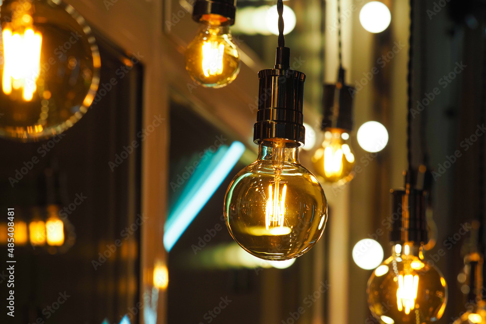 Beautiful and cosy luxury light lamps. Cosy cafe, coffee shop or lounge interior. Vintage, many different vintage light bulbs hanging from ceiling Beautiful and cosy luxury light lamps. Cosy cafe, coffee shop or lounge interior. Vintage, many different vintage light bulbs hanging from ceiling