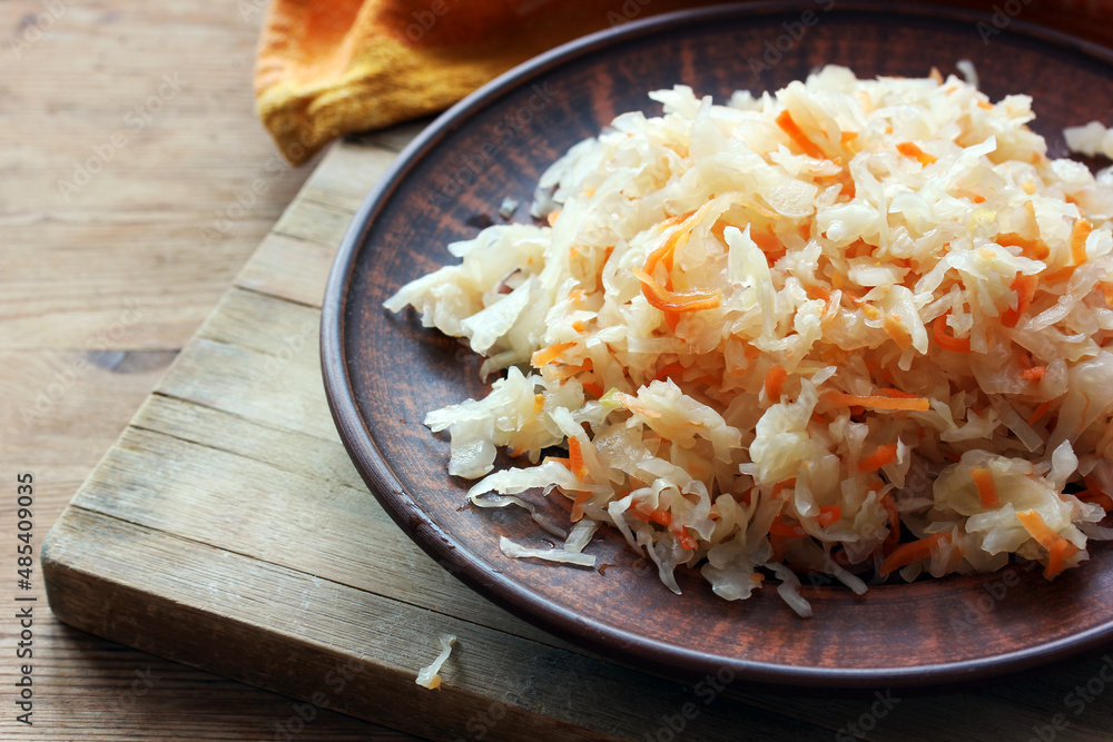 sauerkraut in a clay bowl. homemade food obtained from cabbage. sauerkraut in a clay bowl. homemade food obtained from cabbage.