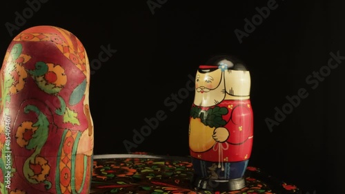 Nesting dolls depicting two old men and a granddaughter. A group of dolls on a Zhostovsky dish photo