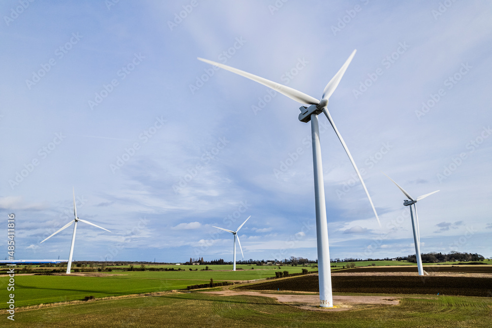 Aerial shot of wind farm turbines with blue cloudy sky, UK Aerial shot of wind farm turbines with blue cloudy sky, UK