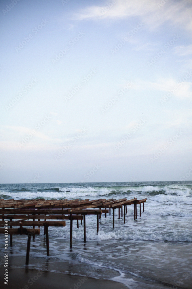 Blue sea wave with white foam and sky in background