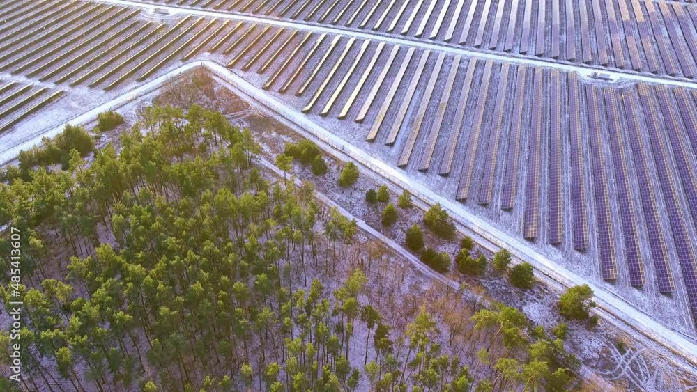 A large number of photovoltaic solar panels installed in a row on the field to generate green electricity at sunset. Renewable energy production concept. Photo from a drone from a bird's eye view A large number of photovoltaic solar panels installed in a row on the field to generate green electricity at sunset. Renewable energy production concept. Photo from a drone from a bird's eye view