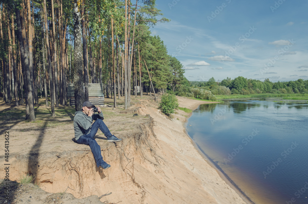 Photographer relaxes in nature near the river.