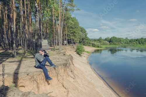 Photographer relaxes in nature near the river.