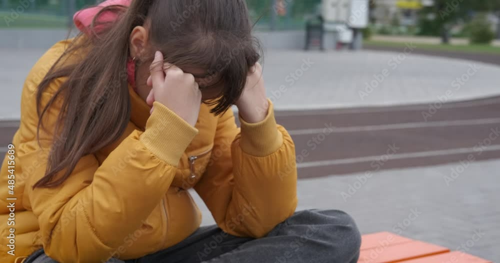 Hopeless girl outdoor. A hopeless sporty teen sits on the sport ground outdoor. Hopeless girl outdoor. A hopeless sporty teen sits on the sport ground outdoor.