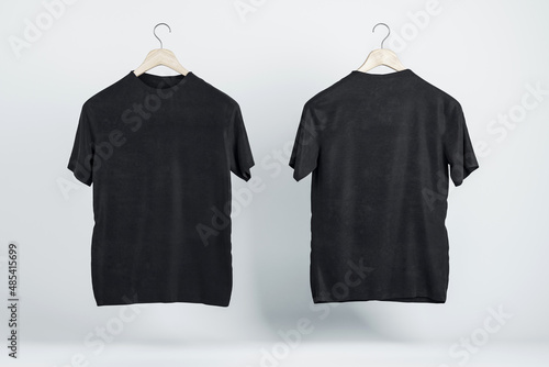 Fototapeta Two blank black t-shirts on wooden hangers with copyspace for your logo on abstract light background