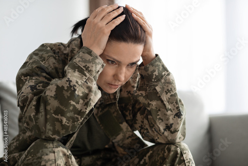 PTSD And Veterans. Depressed Woman In Military Uniform Touching Head In Despair