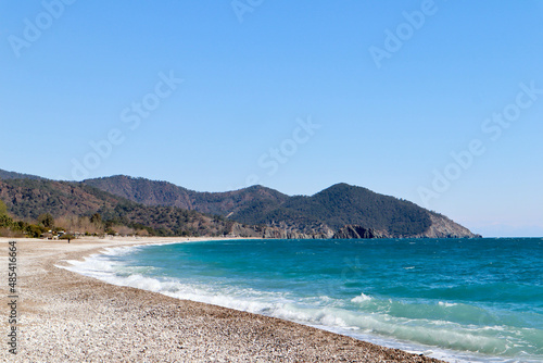 pebble beach of Cirali, Turkey and mediterranean sea with mountain and clouds in spring sunny day © Sergei Timofeev
