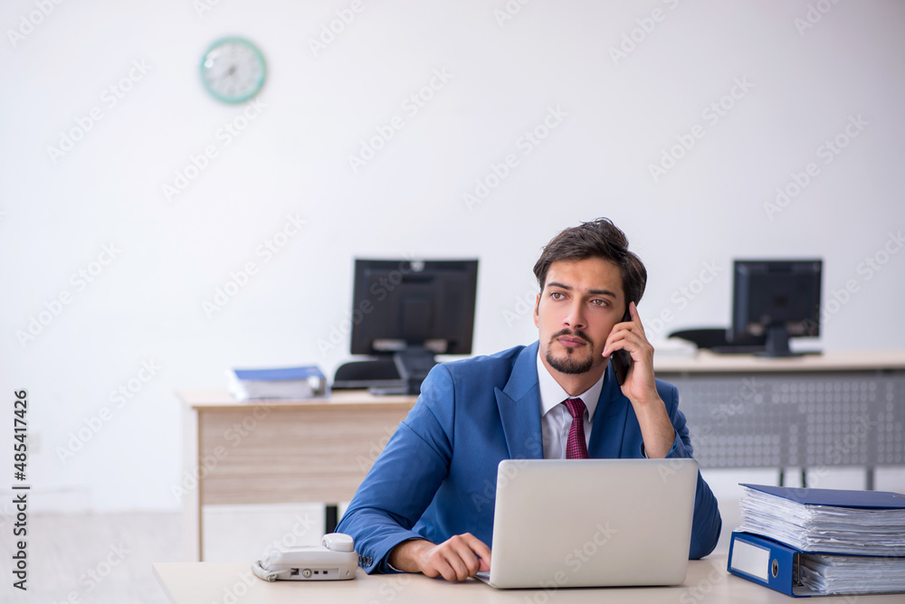 Young male employee working in the office Young male employee working in the office