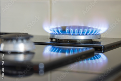 Blue gas flame on a stove hob, selective focus photo