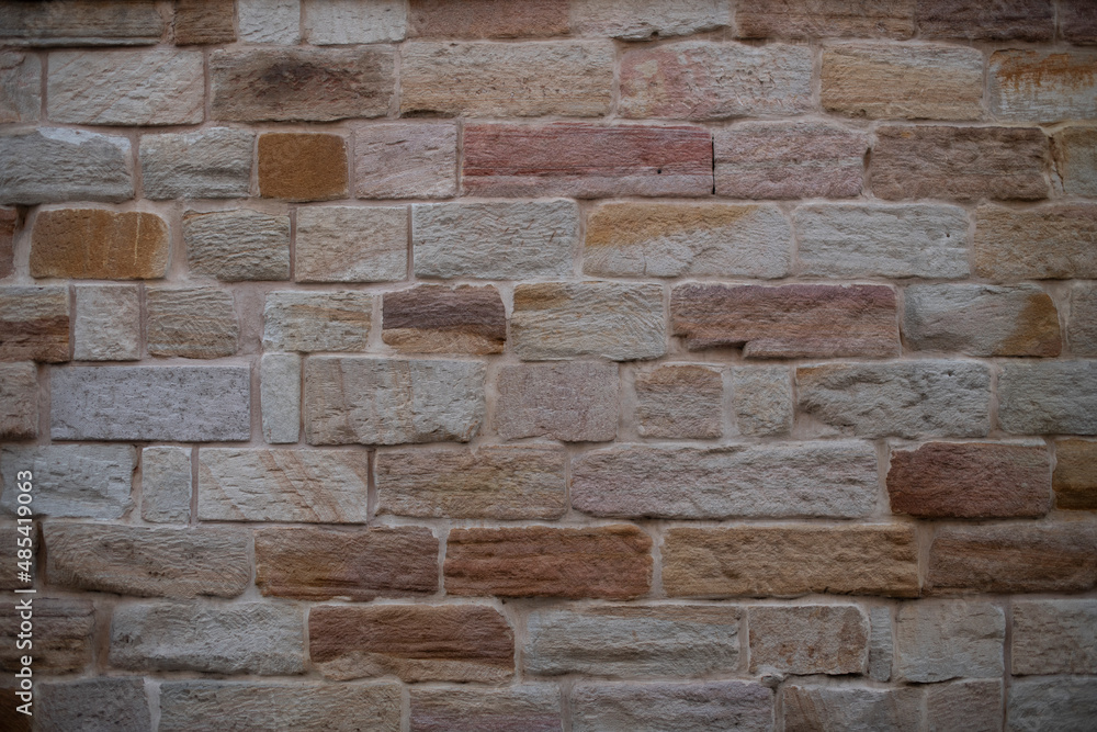 Multi-toned brick wall background. Tones are pink, brown, tan and cream. 
