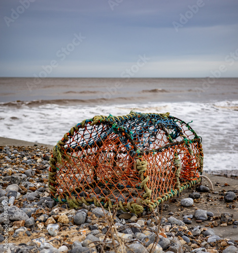 Cromer, Norfolk, UK – February 2022. Close and selective focus on a crab pot, lobster pot or fish trap on Cromer beach on the North Norfolk coast