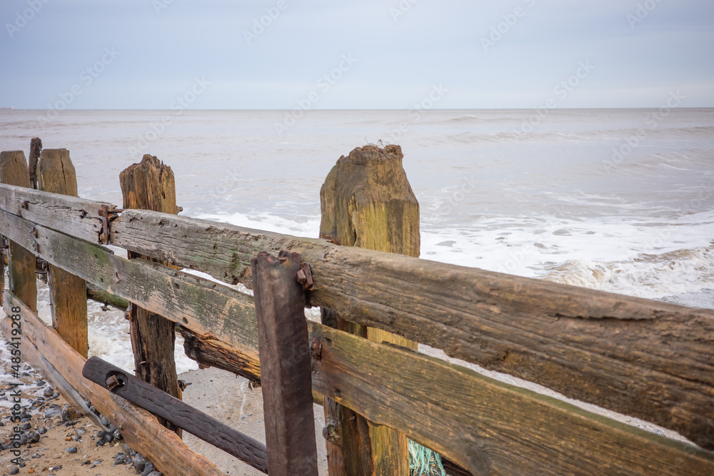 Wooden groynes to protect the fragile cliffs from coastal erosion on Cromer beach Wooden groynes to protect the fragile cliffs from coastal erosion on Cromer beach