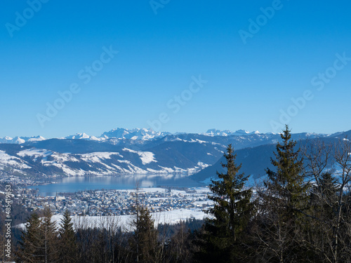 Bautiful winter landscape in Switzerland: View towards lake Aegeri with surrounding snow-covered hills and mountains photo