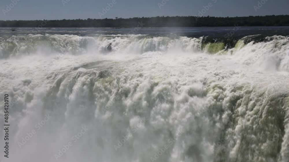 Slow motion shot of Iguazu waterfall. The beautiful falling water texture and pattern creating a mist. Slow motion shot of Iguazu waterfall. The beautiful falling water texture and pattern creating a mist.