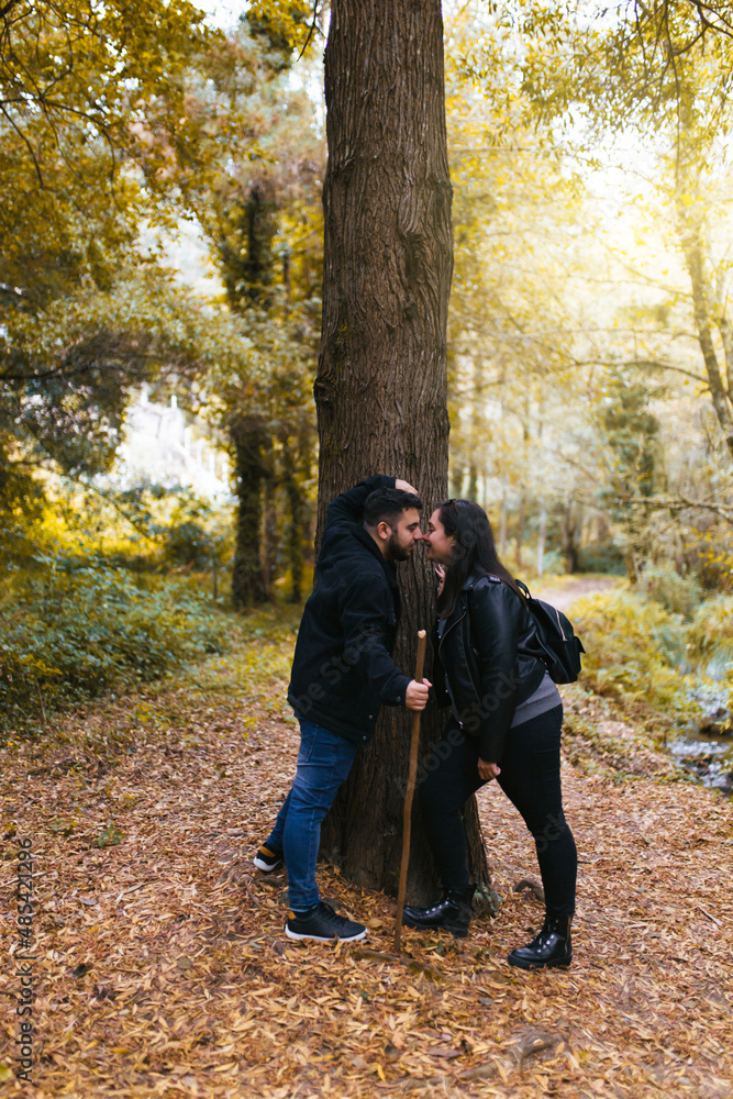 Couple in love touching their noses during an excursion in the forest