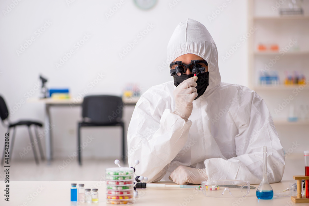 Young male chemist in drugs synthesis concept Young male chemist in drugs synthesis concept