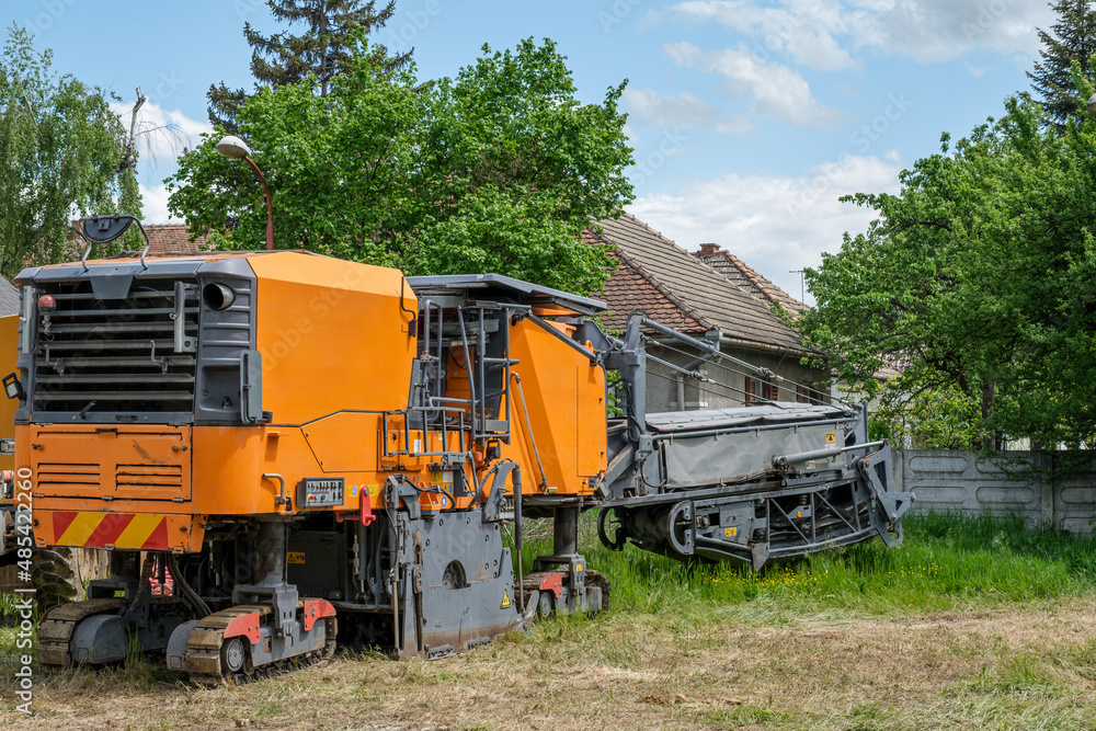 Industrial pavement machine parked on the grass Industrial pavement machine parked on the grass