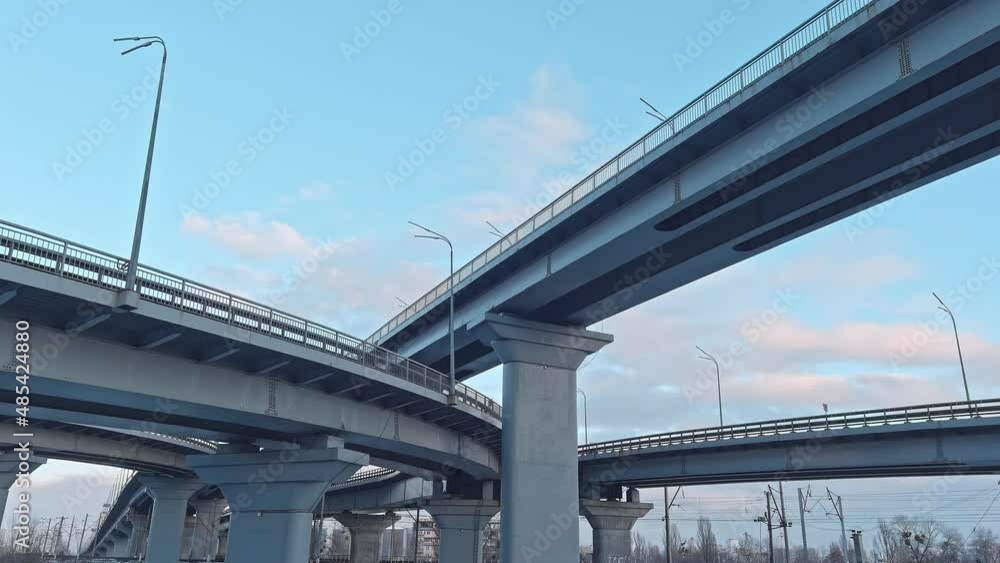 A wide asphalt road with white markings in the center with a dense stream of cars traveling at high speed in a big city. Aerial view taken from drone A wide asphalt road with white markings in the center with a dense stream of cars traveling at high speed in a big city. Aerial view taken from drone