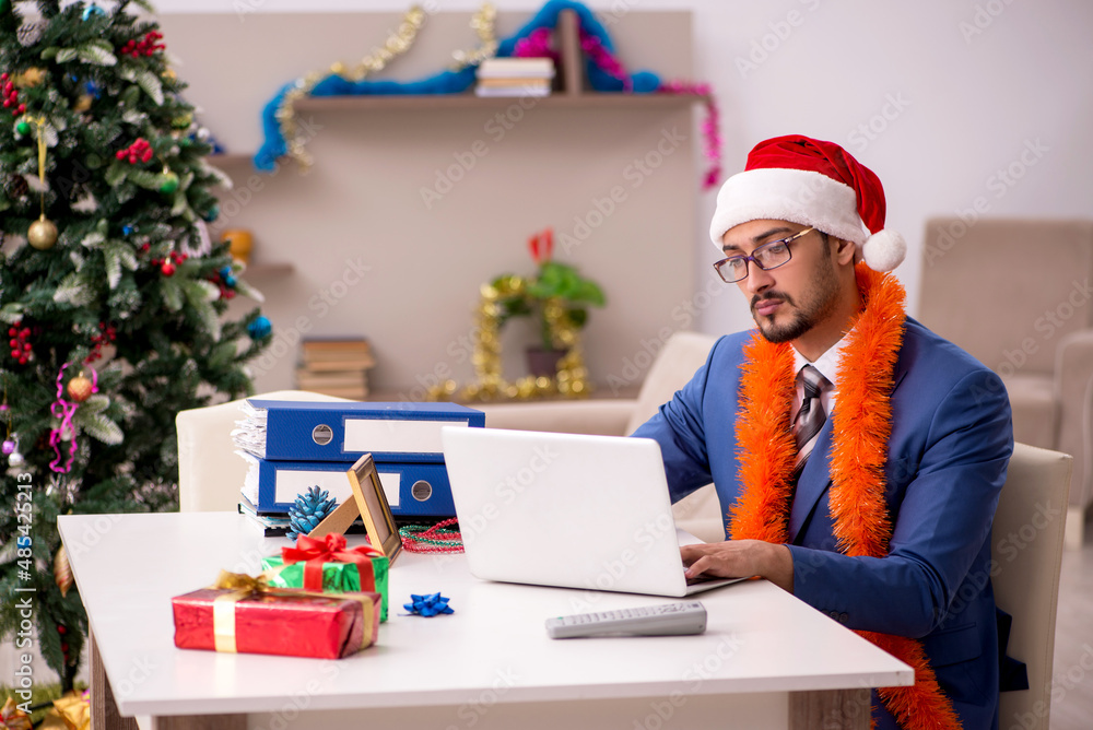 Young businessman working from home at Christmas eve Young businessman working from home at Christmas eve