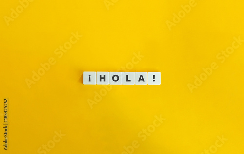 Hola word on letter tiles on yellow background. Minimal aesthetics. photo