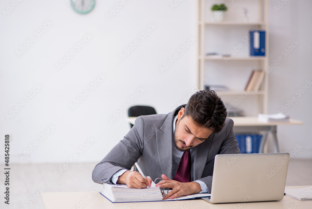 Young male employee working in the office Young male employee working in the office