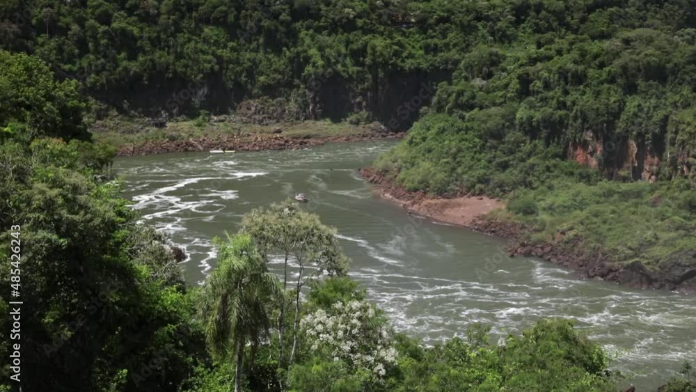 Tourism. View of the river in the South American jungle. The green and lush rainforest vegetation in Iguazu national park in the frontier between Argentina and Brazil. Tourism. View of the river in the South American jungle. The green and lush rainforest vegetation in Iguazu national park in the frontier between Argentina and Brazil.