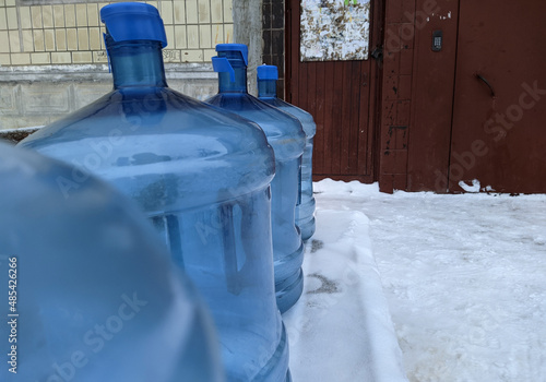 big blue and empty water bottles on benches in winter. photo