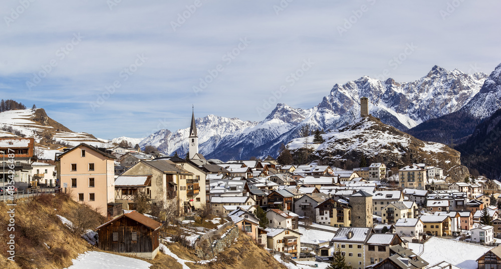 Panorama of Ardez village with the ruins Steinsberg and chuch, the Alps snow mountain at the background