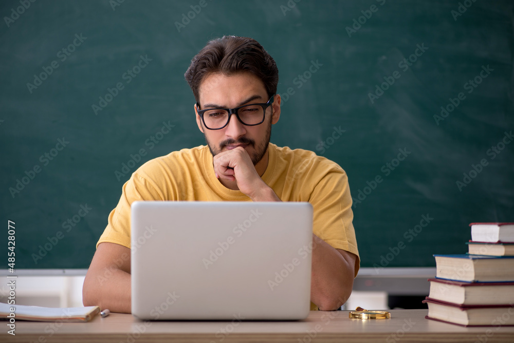 Young male student in telestudying concept Young male student in telestudying concept