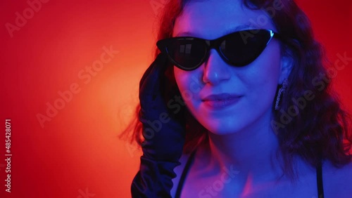 Wallpaper Mural Trendy sunglasses. Eyewear fashion. Female elegance. Portrait of attractive charming woman in stylish glasses in colorful neon light on red gradient. Torontodigital.ca