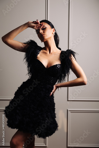 Murais de parede Graceful, tanned, elegant young woman in black evening dress posing in vintage interior