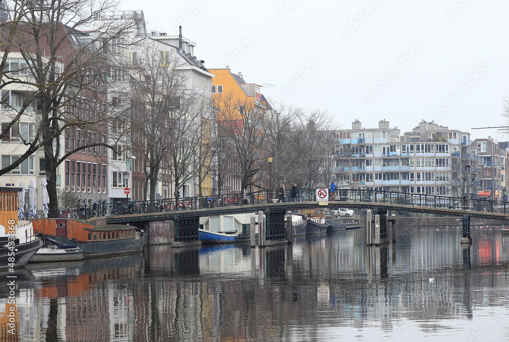 Amsterdam Zwanenburgwal Canal View with Bridge, Boats, Building Facades and Reflection, Netherlands