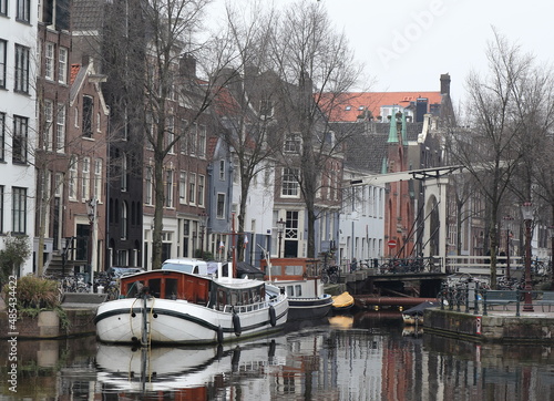 Amsterdam Groenburgwal Canal View with Boat, Bridge and Traditional Architecture, Netherlands photo