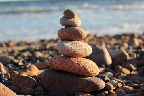pedras sobrepostas na vertical, na margem do rio, em exercício de meditacao e equilíbrio photo