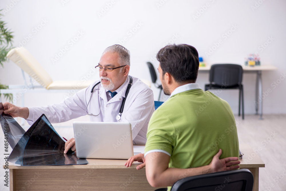 Young man visiting old male doctor radiologist Young man visiting old male doctor radiologist