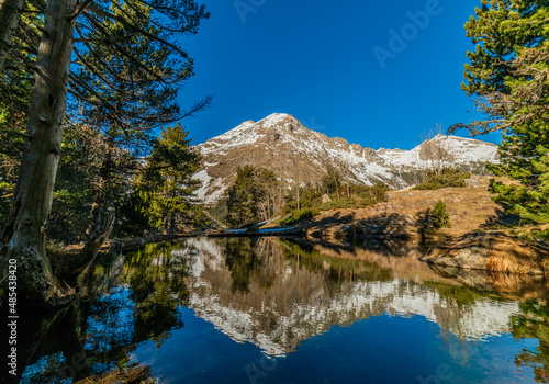 Snowy mountain reflected on the water of a lake in the Pyrenees, Spain. Mountain landscape.