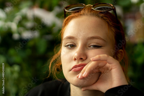 Portrait of a young girl. A girl of European appearance. The teenager looks into the camera with a tired look.