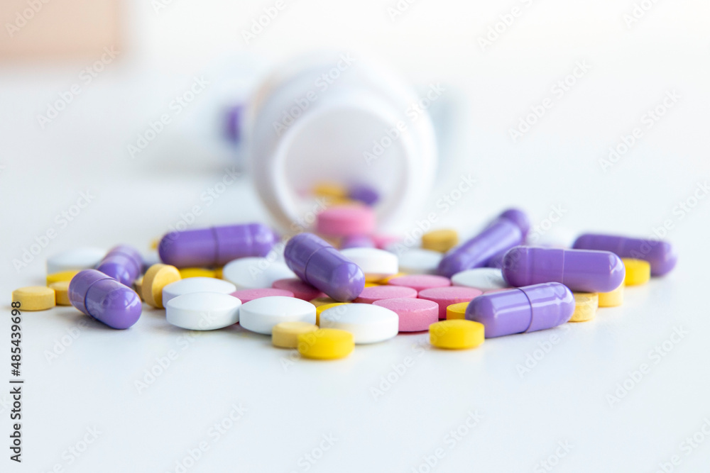 Influenza treatment. Many colorful pills and capsules on a white background Influenza treatment. Many colorful pills and capsules on a white background