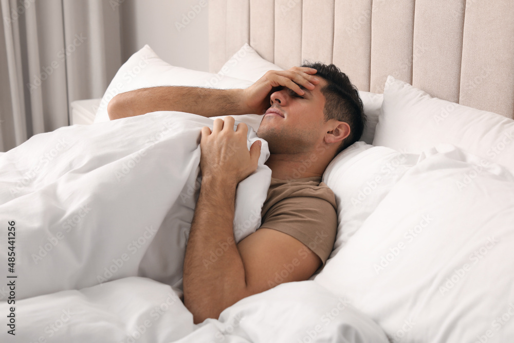 Handsome man lying in bed at home Handsome man lying in bed at home