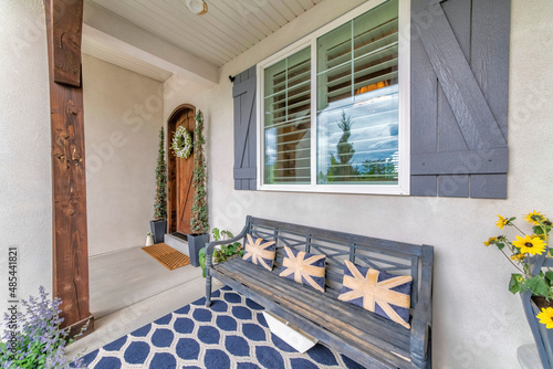 Decorated front porch with bench, flowers and carpet