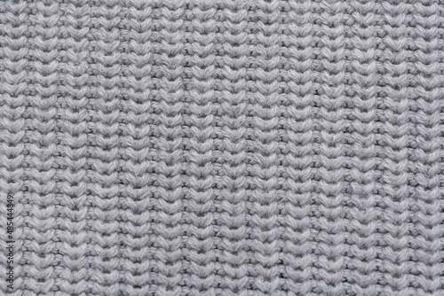 Grey knitted fabric as background, top view