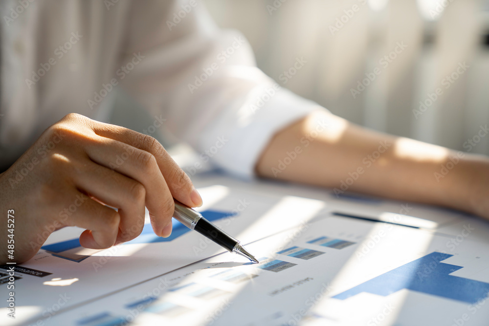 Businesswoman using document paper calculator and laptop analysis graph report company financial budget report investment and cost work progress and planning for future in the office room. Businesswoman using document paper calculator and laptop analysis graph report company financial budget report investment and cost work progress and planning for future in the office room.