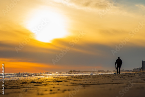 Man walking on beach with metal detector around sunset © Ajax9