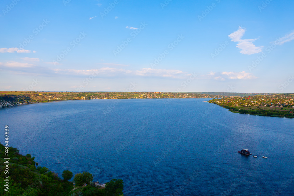 Large river flowing , view from above . Calm river water . Rustic riverside scenery 