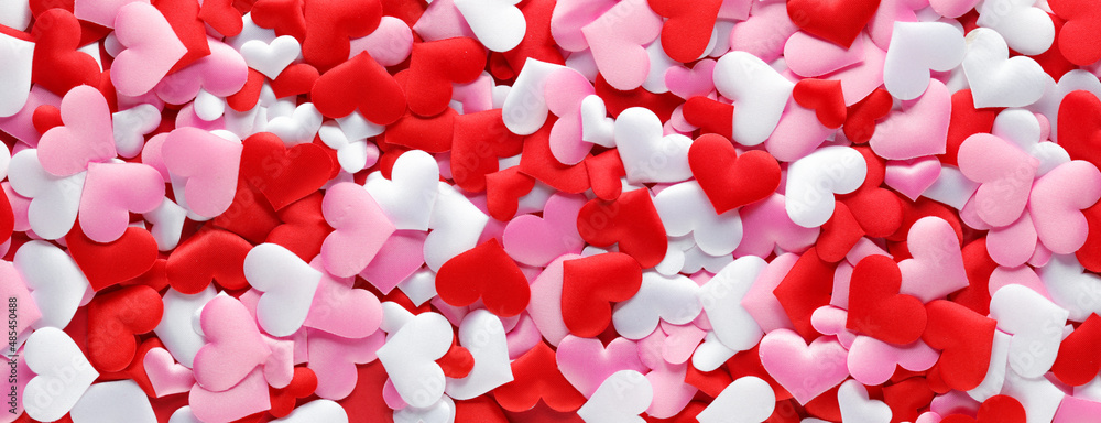 Pile of soft red, pink, and white cloth hearts for romantic or Valentine's Day background